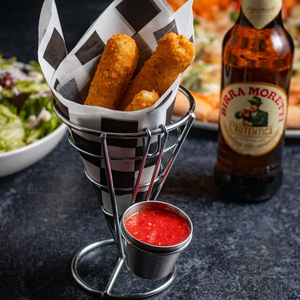 Mozzarella sticks in a checkered paper cone with marinara sauce, a beer, and salad.