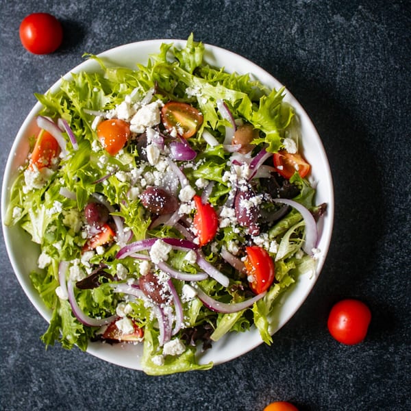 Fresh Mr. G's Italian Pizzeria house salad with lettuce, tomatoes, onions, olives, and feta cheese.